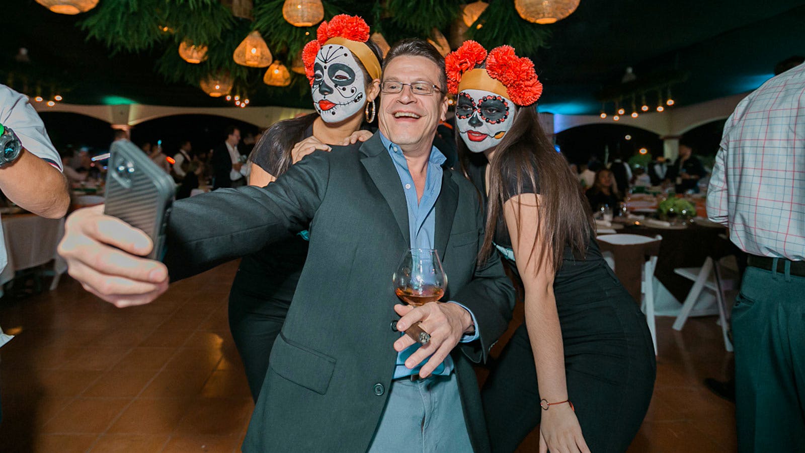 A guest snaps a photo while enjoying premium cigars and spirits at a Puro Sabor dinner.